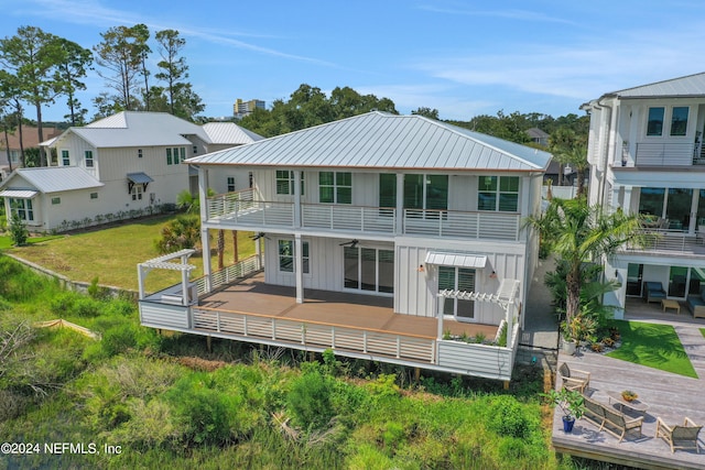 back of property featuring a wooden deck and a yard