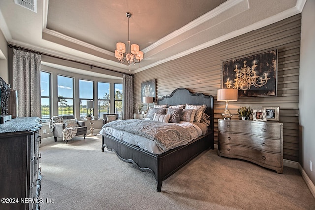 bedroom with a notable chandelier, a tray ceiling, ornamental molding, and carpet flooring