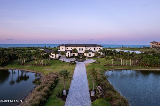 aerial view at dusk featuring a water view