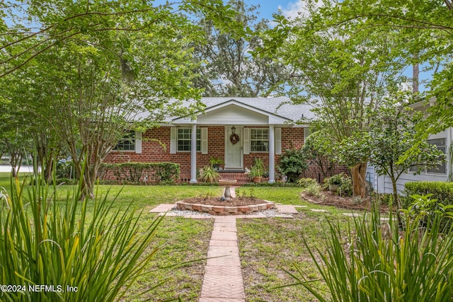 ranch-style home featuring brick siding, a front yard, and a shingled roof