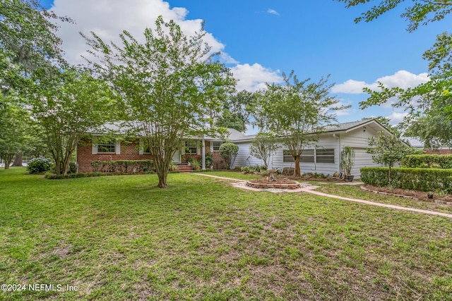 ranch-style home with an attached garage, brick siding, and a front yard