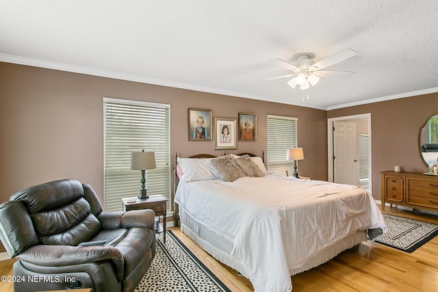 bedroom featuring a textured ceiling, light wood finished floors, a ceiling fan, and crown molding