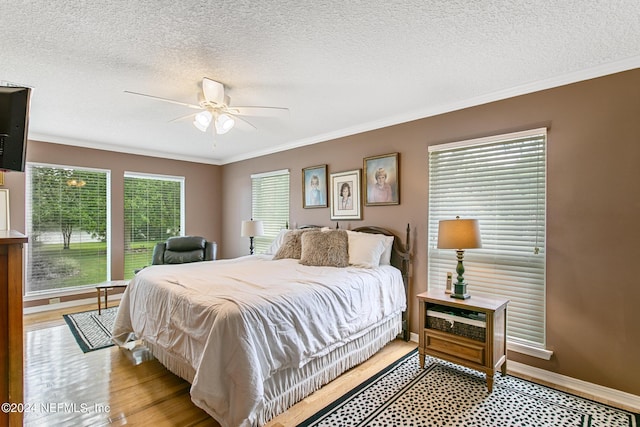 bedroom featuring ornamental molding, a textured ceiling, and baseboards