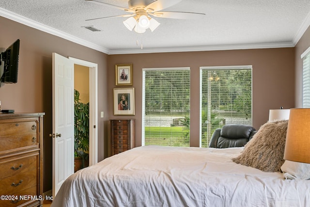 bedroom featuring a textured ceiling, ceiling fan, visible vents, and crown molding