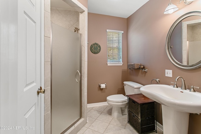 bathroom featuring tile patterned flooring, baseboards, a shower stall, and toilet