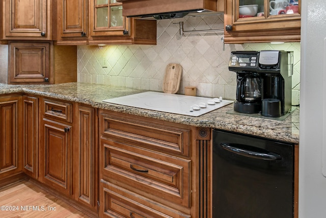 kitchen featuring white electric stovetop, extractor fan, decorative backsplash, and brown cabinets