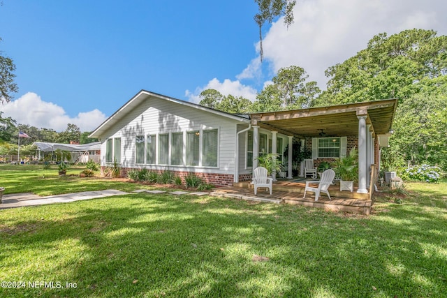 back of house featuring brick siding and a lawn