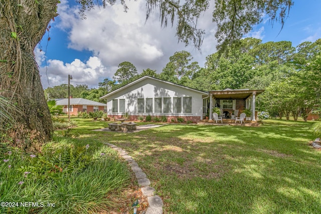 back of house with a patio area, brick siding, and a lawn