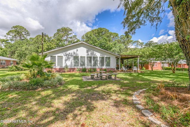 back of property with a patio, brick siding, and a lawn