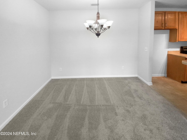 unfurnished dining area with light carpet and a notable chandelier