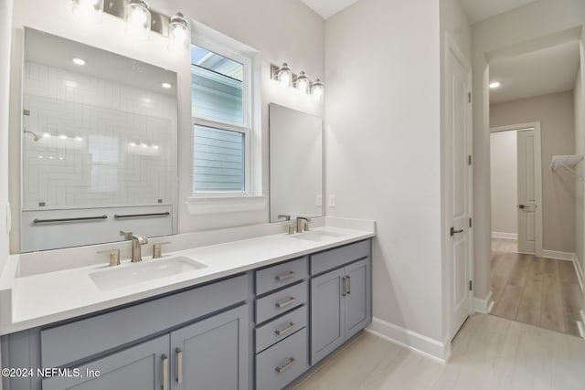 bathroom featuring a shower, hardwood / wood-style floors, and vanity