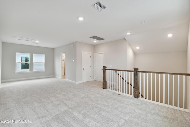 unfurnished room with light carpet and vaulted ceiling