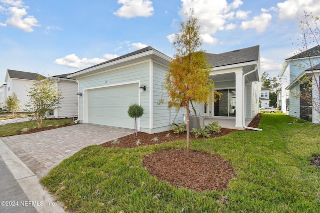 ranch-style home featuring a garage and a front lawn