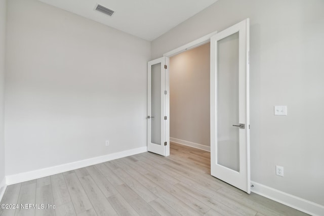 unfurnished bedroom with light wood-type flooring and french doors