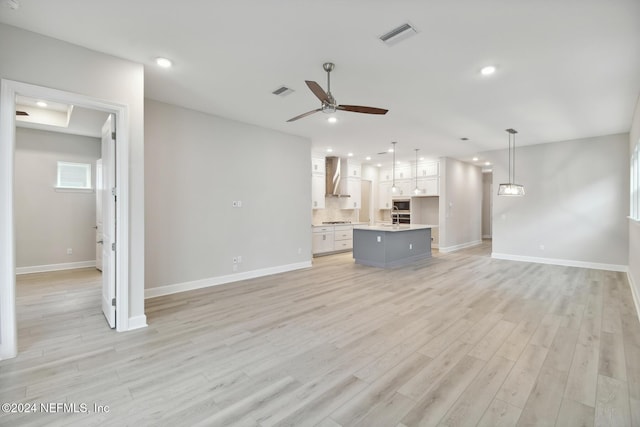 unfurnished living room featuring light wood-type flooring and ceiling fan