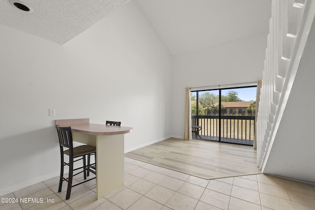 tiled dining space with high vaulted ceiling