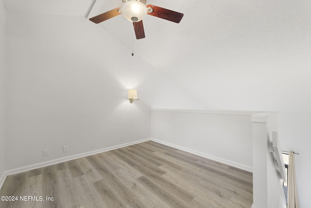 unfurnished room featuring lofted ceiling and light hardwood / wood-style flooring