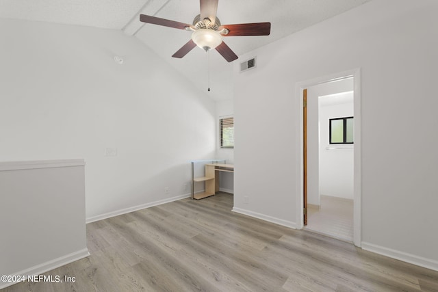 unfurnished bedroom with ceiling fan, vaulted ceiling, multiple windows, and light hardwood / wood-style floors