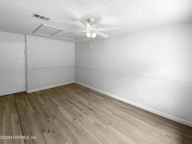 spare room with a textured ceiling, light hardwood / wood-style flooring, and ceiling fan