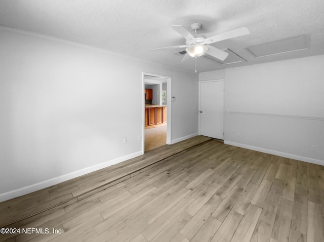 spare room with ceiling fan, a textured ceiling, and light hardwood / wood-style flooring