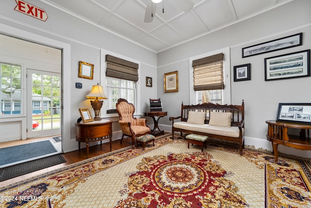 sitting room with coffered ceiling, ceiling fan, hardwood / wood-style floors, and ornamental molding