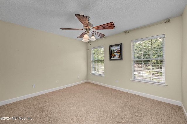 spare room with carpet, ceiling fan, and a textured ceiling