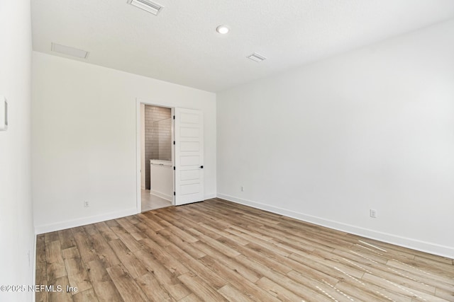 empty room with visible vents, baseboards, and wood finished floors