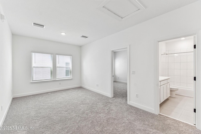 unfurnished bedroom featuring light carpet, attic access, visible vents, and baseboards