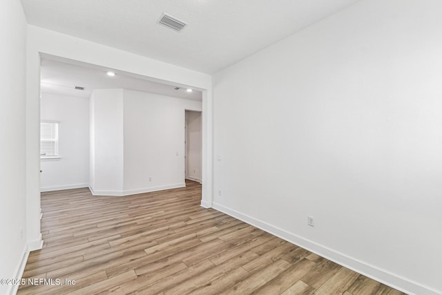 spare room featuring light wood-style flooring, visible vents, baseboards, and recessed lighting