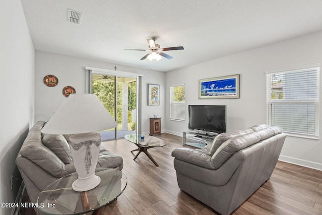 living room featuring ceiling fan, a textured ceiling, and hardwood / wood-style flooring