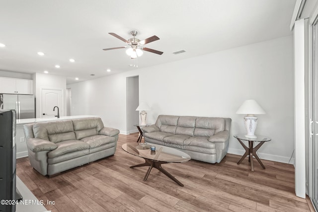 living room with ceiling fan and light wood-type flooring