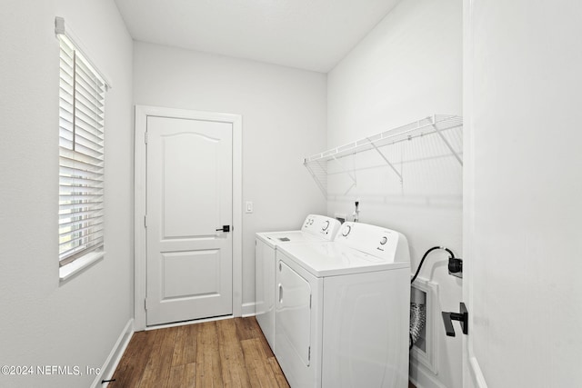 washroom with washing machine and clothes dryer and wood-type flooring