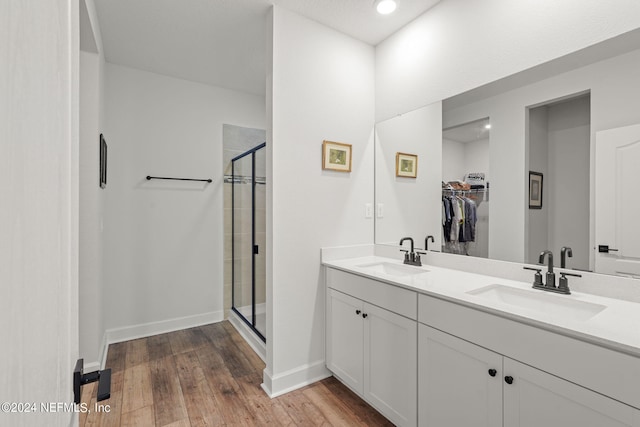 bathroom featuring hardwood / wood-style floors, vanity, and a shower with door