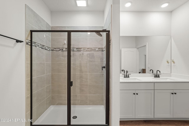 bathroom featuring hardwood / wood-style flooring, vanity, and an enclosed shower