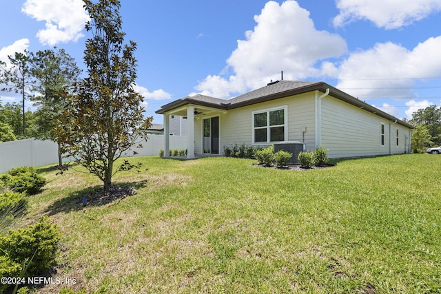 back of house with a lawn, ceiling fan, and central AC unit