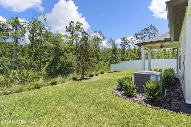 view of yard with central air condition unit and ceiling fan