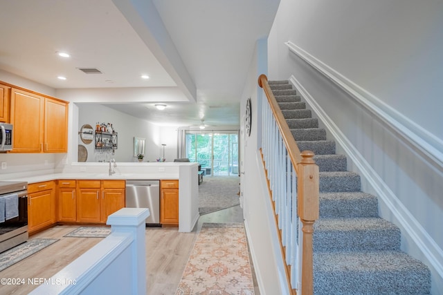 kitchen with sink, stainless steel appliances, and light hardwood / wood-style flooring