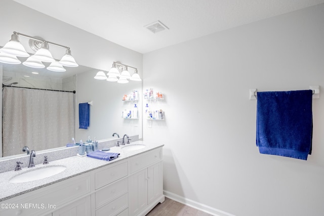 bathroom featuring a textured ceiling, vanity, hardwood / wood-style flooring, and curtained shower