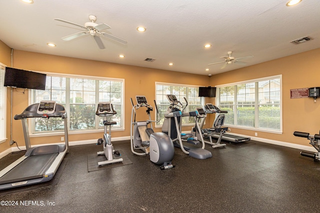 gym featuring ceiling fan and a textured ceiling