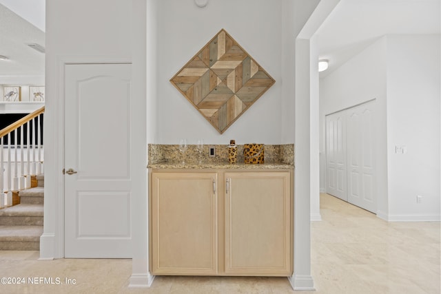 bar with light brown cabinetry and light tile patterned floors