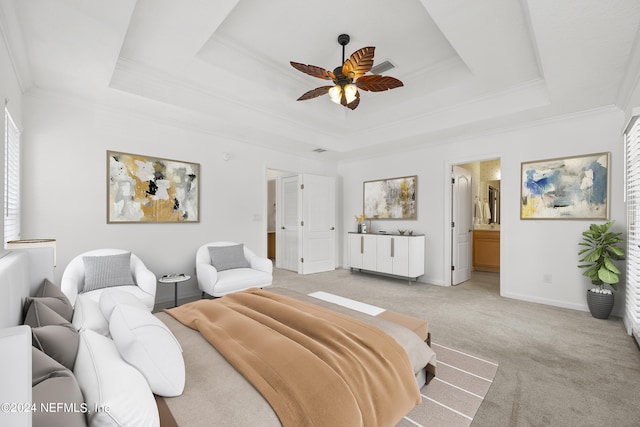 bedroom with connected bathroom, a tray ceiling, ceiling fan, and ornamental molding