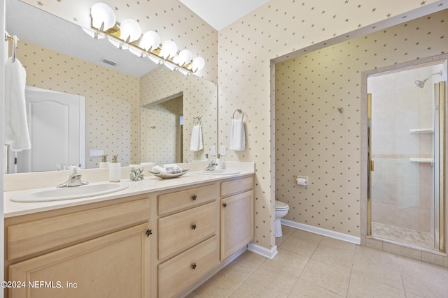 bathroom with tile patterned flooring, a tile shower, vanity, and toilet