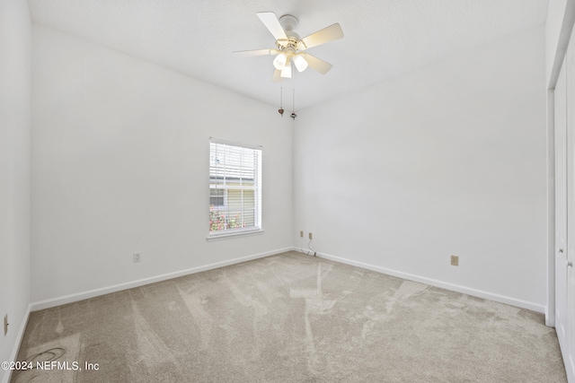 carpeted spare room featuring ceiling fan