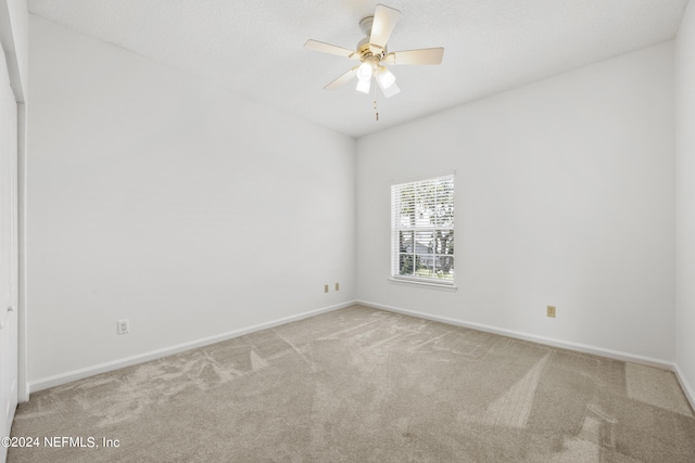 spare room with ceiling fan and light colored carpet