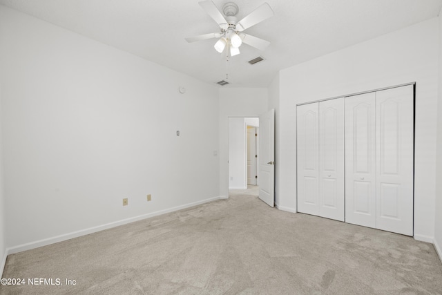 unfurnished bedroom featuring a closet, ceiling fan, and light colored carpet