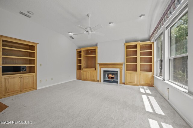 unfurnished living room with lofted ceiling, carpet flooring, and ceiling fan