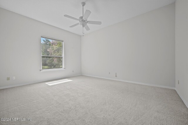 carpeted spare room with ceiling fan