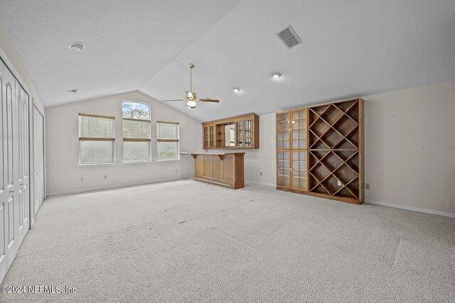 unfurnished living room with lofted ceiling, carpet, and ceiling fan