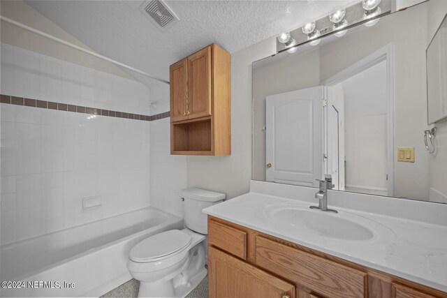 full bathroom with vanity, toilet, a textured ceiling, and bathtub / shower combination