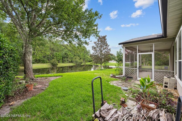 view of yard with a water view and a sunroom